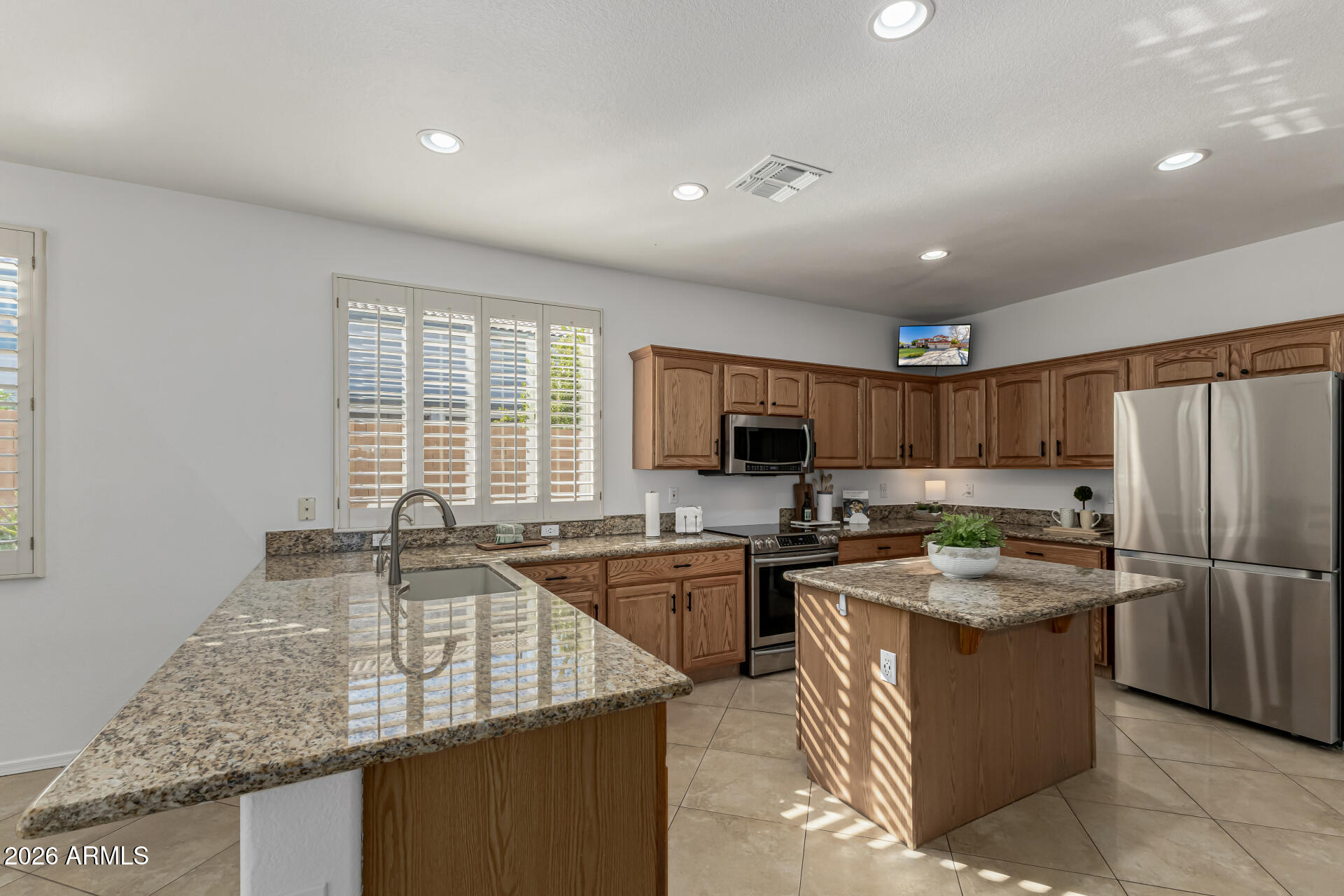 1099 South Justine Court Gilbert, AZ 85296 - Photo 8 of 60 a kitchen with stainless steel appliances granite countertop a sink stove and refrigerator