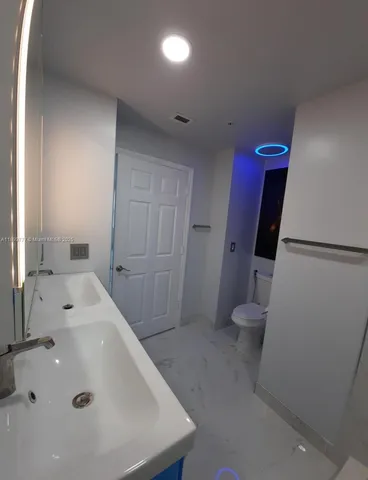 a white toilet sitting next to a bathroom sink