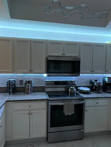 a kitchen with granite countertop a stove and a sink