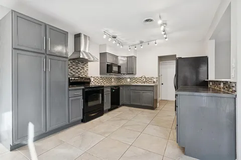 a kitchen with stainless steel appliances a refrigerator sink and cabinets