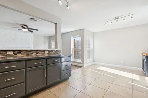 a spacious bathroom with a granite countertop sink a mirror and a shower