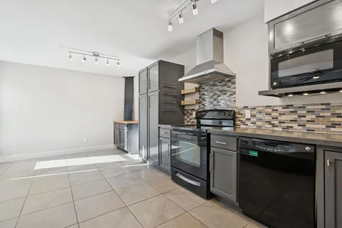 a kitchen with stainless steel appliances granite countertop a stove a sink and a microwave