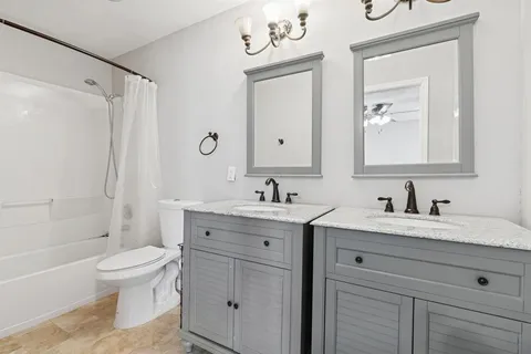 a bathroom with a granite countertop sink a toilet and a bathtub