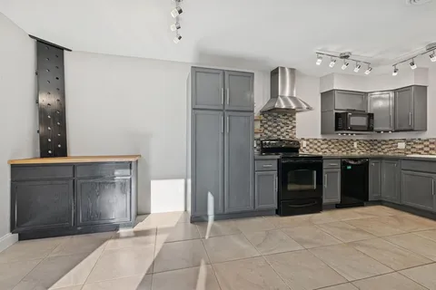 a large kitchen with a stove and a refrigerator