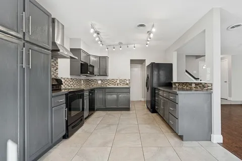a kitchen with stainless steel appliances granite countertop a stove top oven and refrigerator