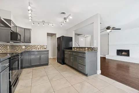 a kitchen with granite countertop a refrigerator and a stove top oven
