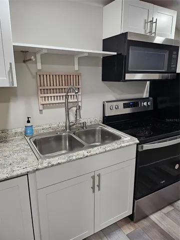 a kitchen with stainless steel appliances granite countertop a sink stove and microwave