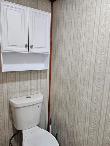 a bathroom with a toilet a sink and a window