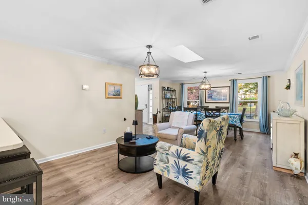 a kitchen with a sink a stove a refrigerator and white cabinets with wooden floor