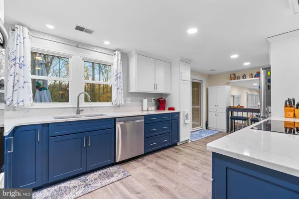 a large kitchen with stainless steel appliances granite countertop a large counter top a sink and cabinets