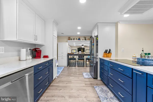 a kitchen with stainless steel appliances kitchen island refrigerator sink and cabinets