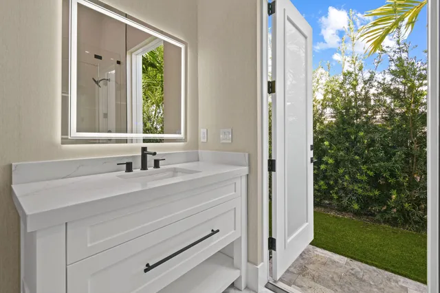 a bathroom with a tub a sink and a mirror