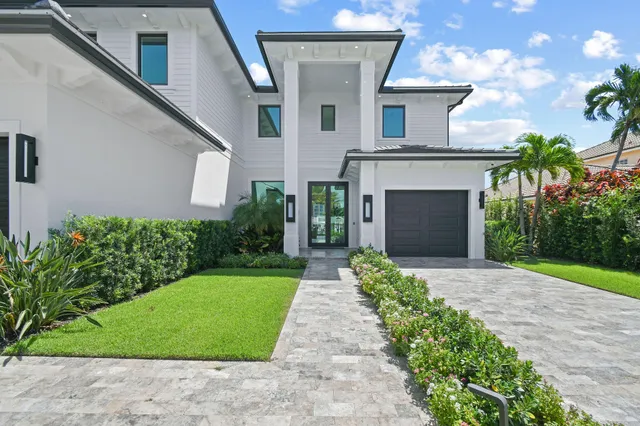 a front view of a house with a garden and plants