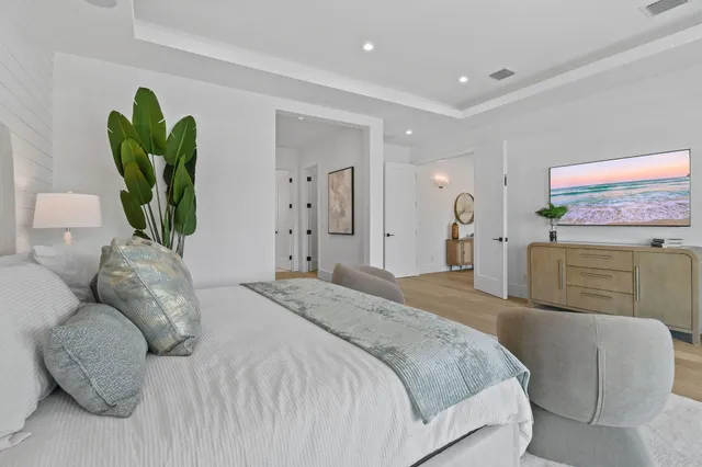 a living room with couches a coffee table and a flat screen tv with kitchen view