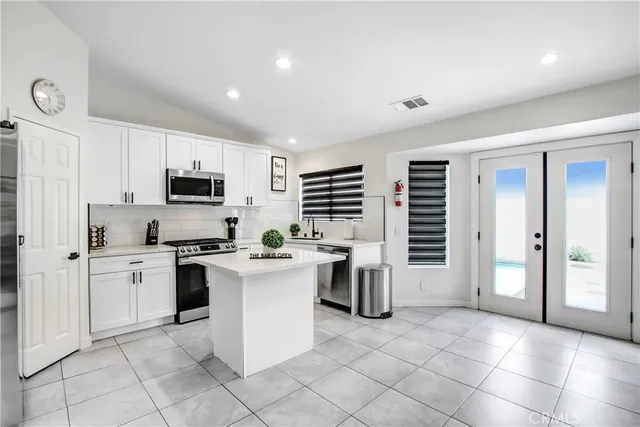 a kitchen with white cabinets a sink and appliances