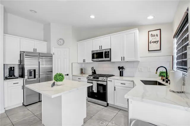 a kitchen with white cabinets and appliances