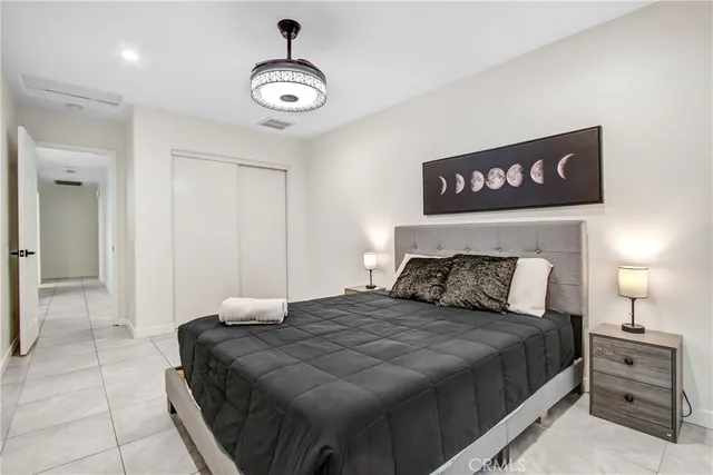 a bedroom with a large bed and a chandelier