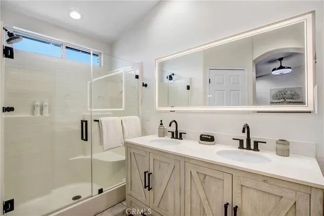 a bathroom with a sink a mirror and shower
