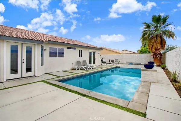a view of a house with swimming pool and sitting area