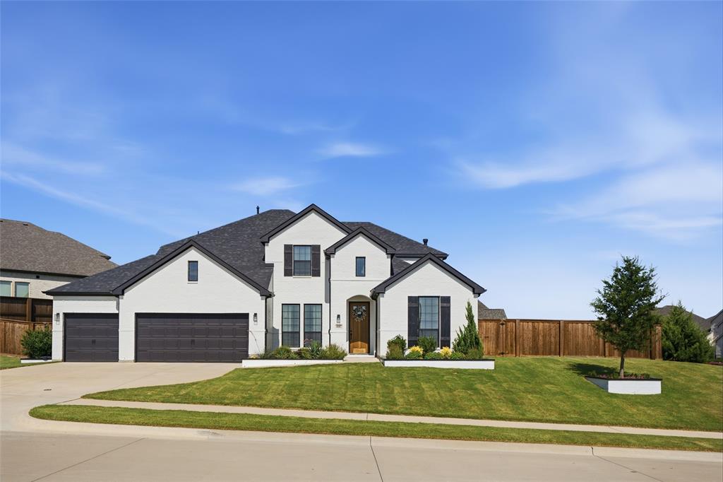 4202 Crown Run Road Midlothian, TX 76065 - Photo 30 of 34 Contemporary residence featuring a white brick exterior with dark trim and shutters, a dark shingled roof, an attached two-car garage, an additional single-car garage, and a manicured lawn with landscaping