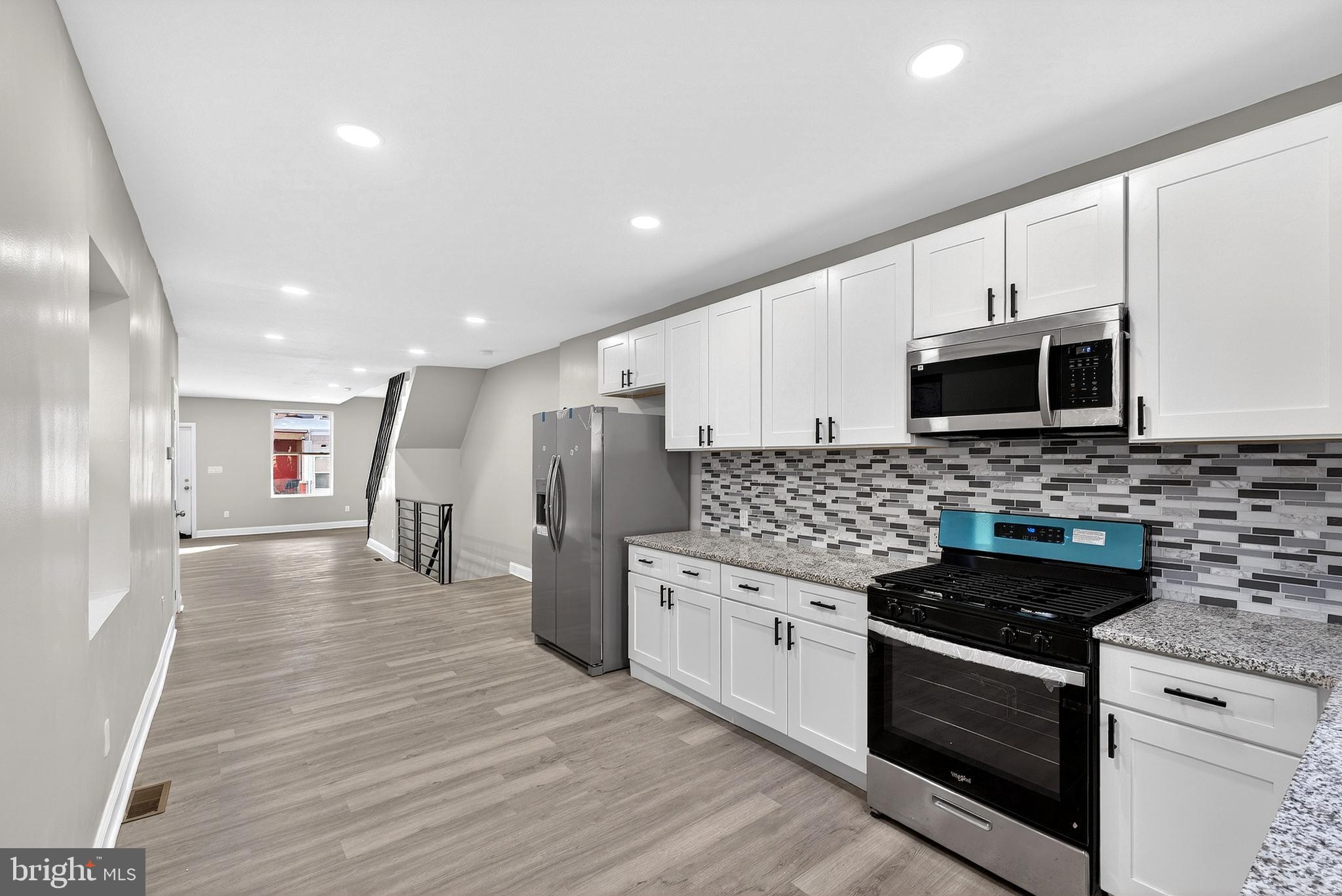 5443 Irving Street Philadelphia, PA 19139 - Photo 14 of 50 a kitchen with stainless steel appliances kitchen island granite countertop a stove a sink and a microwave