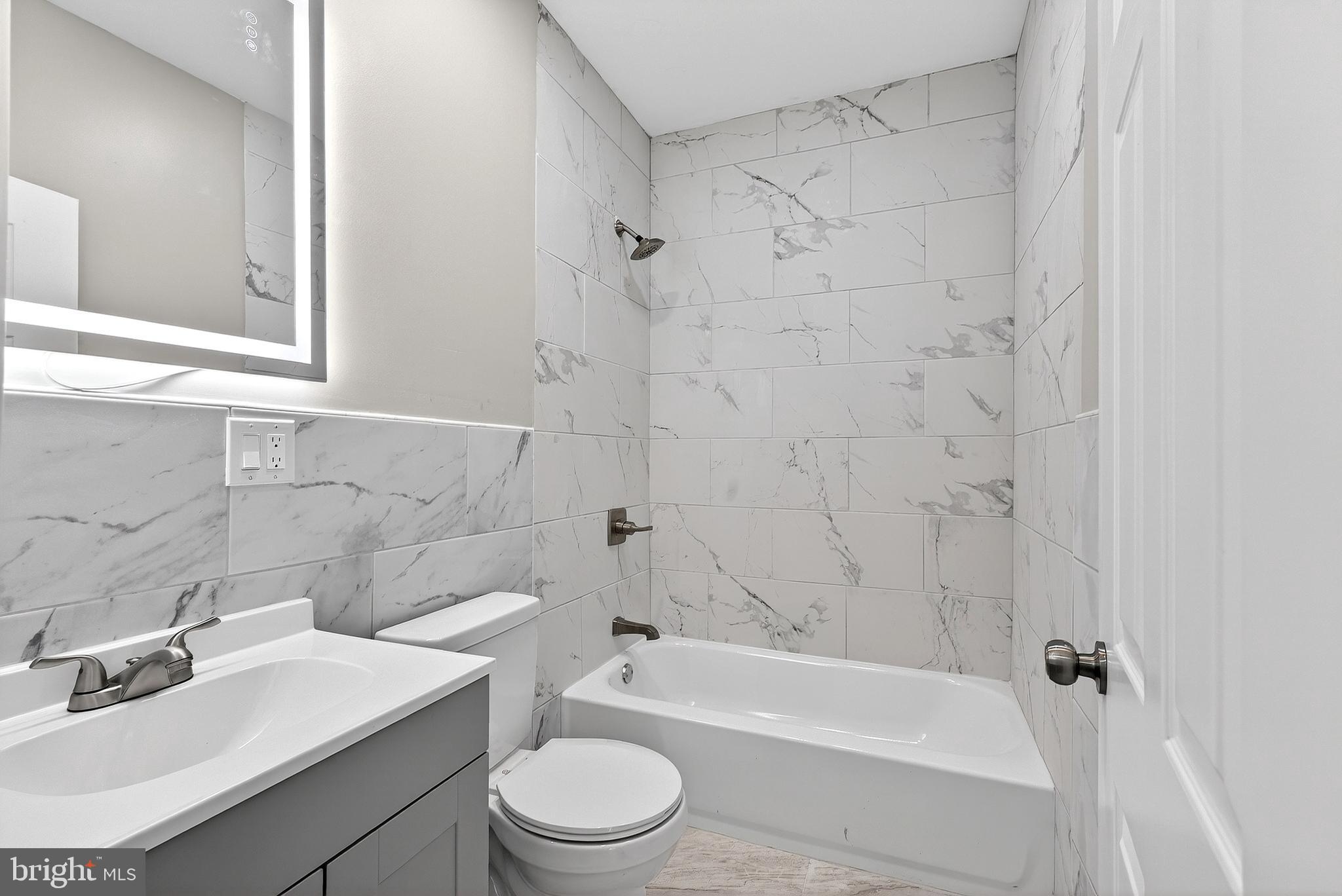 5443 Irving Street Philadelphia, PA 19139 - Photo 27 of 50 a bathroom with a bathtub shower sink vanity and toilet