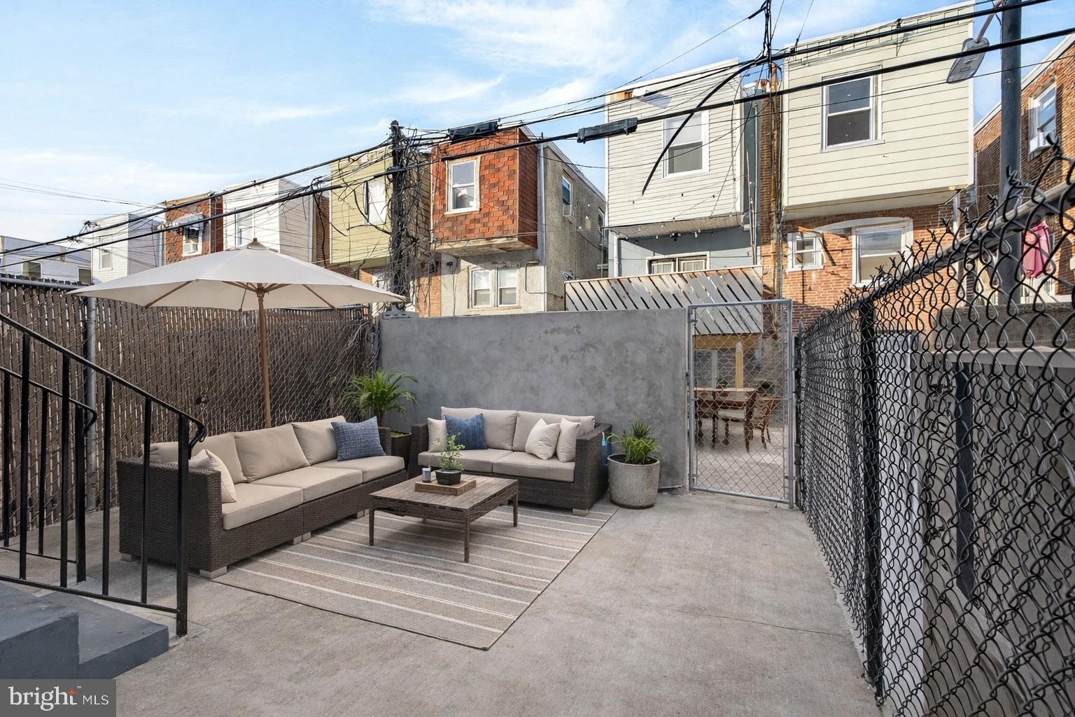 5443 Irving Street Philadelphia, PA 19139 - Photo 44 of 50 a view of a patio with couches and a fire pit and wooden fence