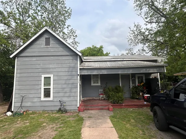 a view of house with yard and outdoor seating