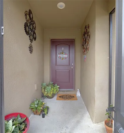 a view of a hallway with wooden floor and a potted plant