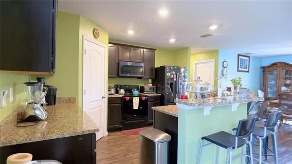 a kitchen with kitchen island granite countertop a sink cabinets and stainless steel appliances