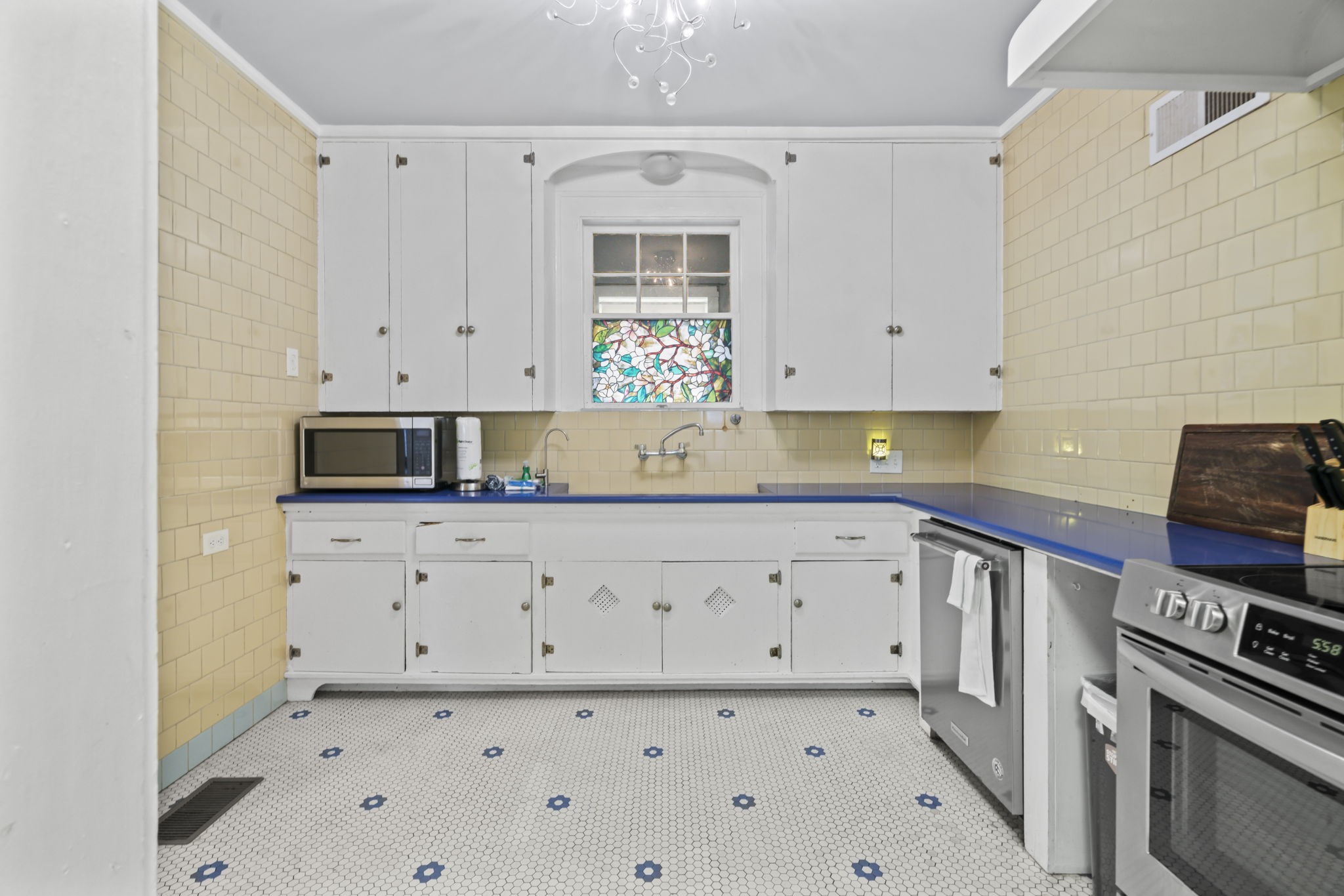 1919 Rosenberg Street Galveston, TX 77550 - Photo 9 of 25 a kitchen with granite countertop white cabinets and stainless steel appliances