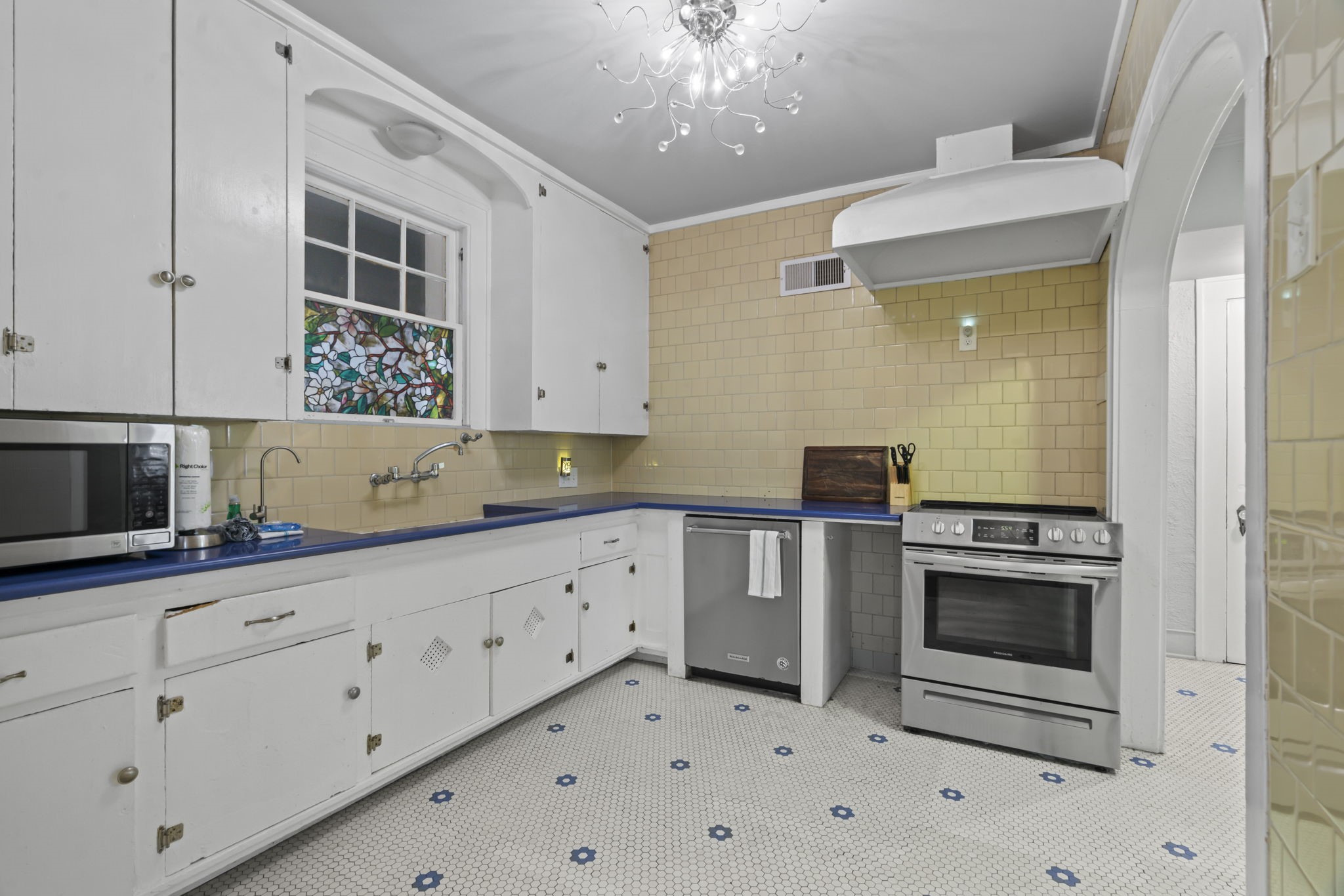 1919 Rosenberg Street Galveston, TX 77550 - Photo 10 of 25 a kitchen with granite countertop white cabinets and stainless steel appliances