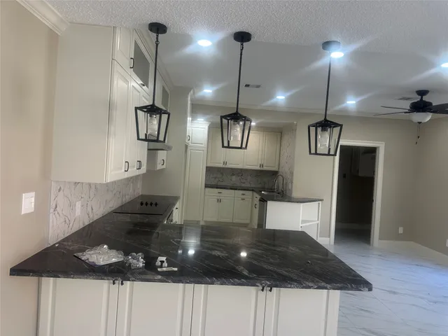 a kitchen with a refrigerator a sink and wooden floor