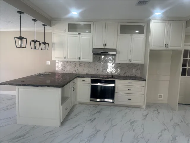 a kitchen with granite countertop a sink and cabinets