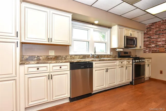 a kitchen with stainless steel appliances granite countertop a stove and a microwave