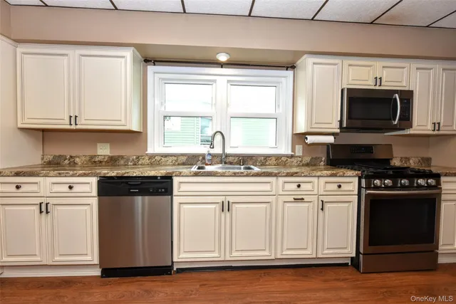 a kitchen with granite countertop white cabinets and a stove