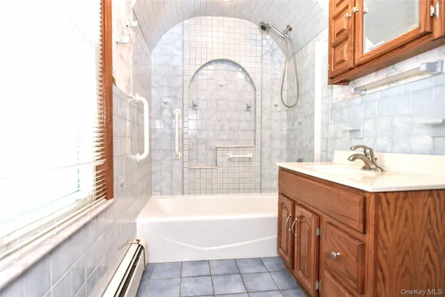 a bathroom with a tub sink and mirror