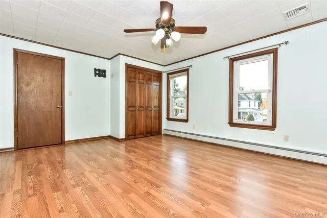 a view of an empty room with a window and a ceiling fan