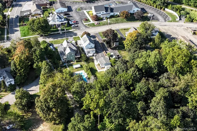 an aerial view of residential houses with outdoor space and trees
