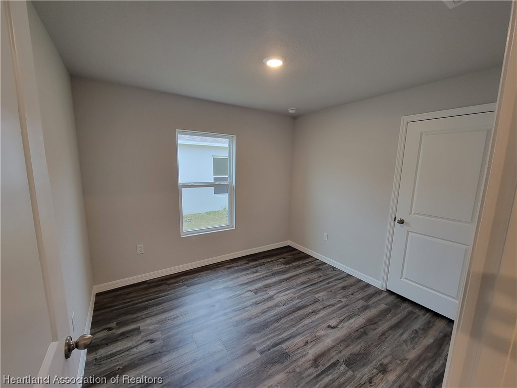 1389 Stone Circle Sebring, FL 33870 - Photo 14 of 39 a view of an empty room with wooden floor and a window