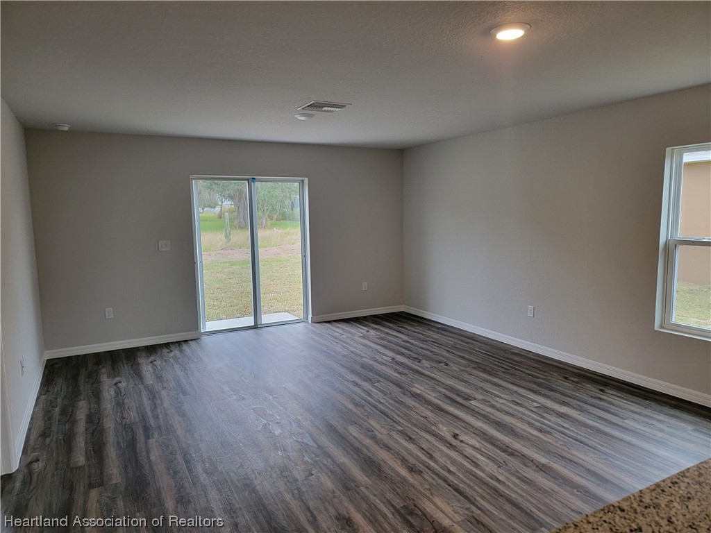 1389 Stone Circle Sebring, FL 33870 - Photo 4 of 39 an empty room with wooden floor and windows