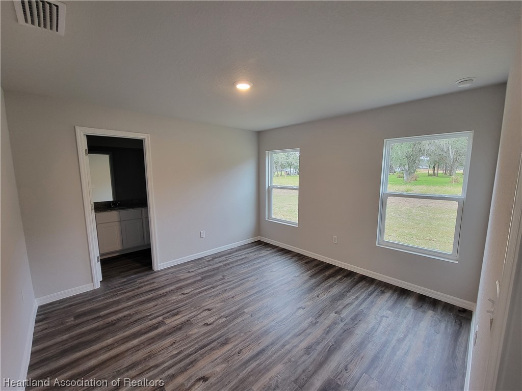 1389 Stone Circle Sebring, FL 33870 - Photo 7 of 39 an empty room with wooden floor and a window