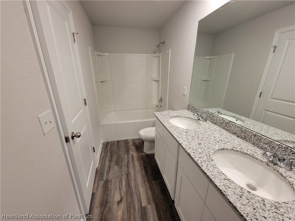1389 Stone Circle Sebring, FL 33870 - Photo 9 of 39 a bathroom with a granite countertop sink toilet and shower