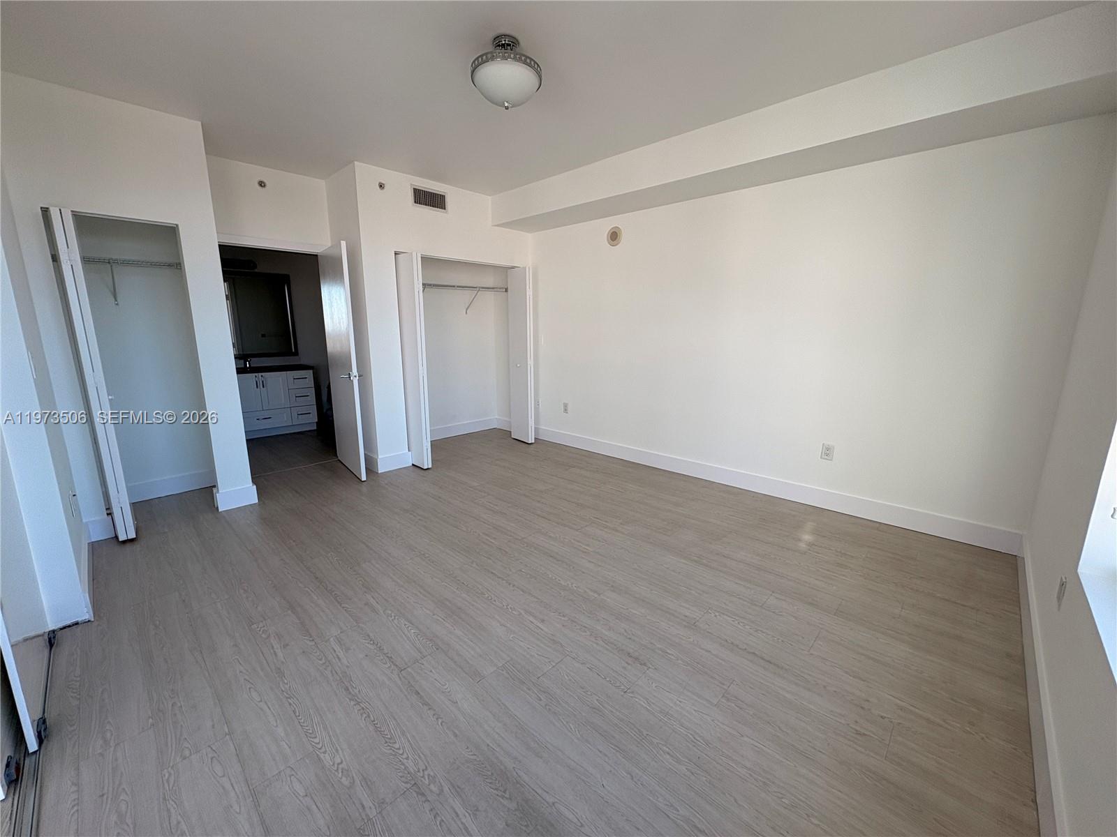90 Southwest 3rd Street, Unit 1205 Miami, FL 33130 - Photo 14 of 41 an empty room with wooden floor and closet