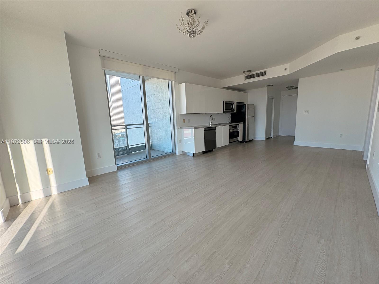 90 Southwest 3rd Street, Unit 1205 Miami, FL 33130 - Photo 5 of 41 an empty room with wooden floor and cabinet