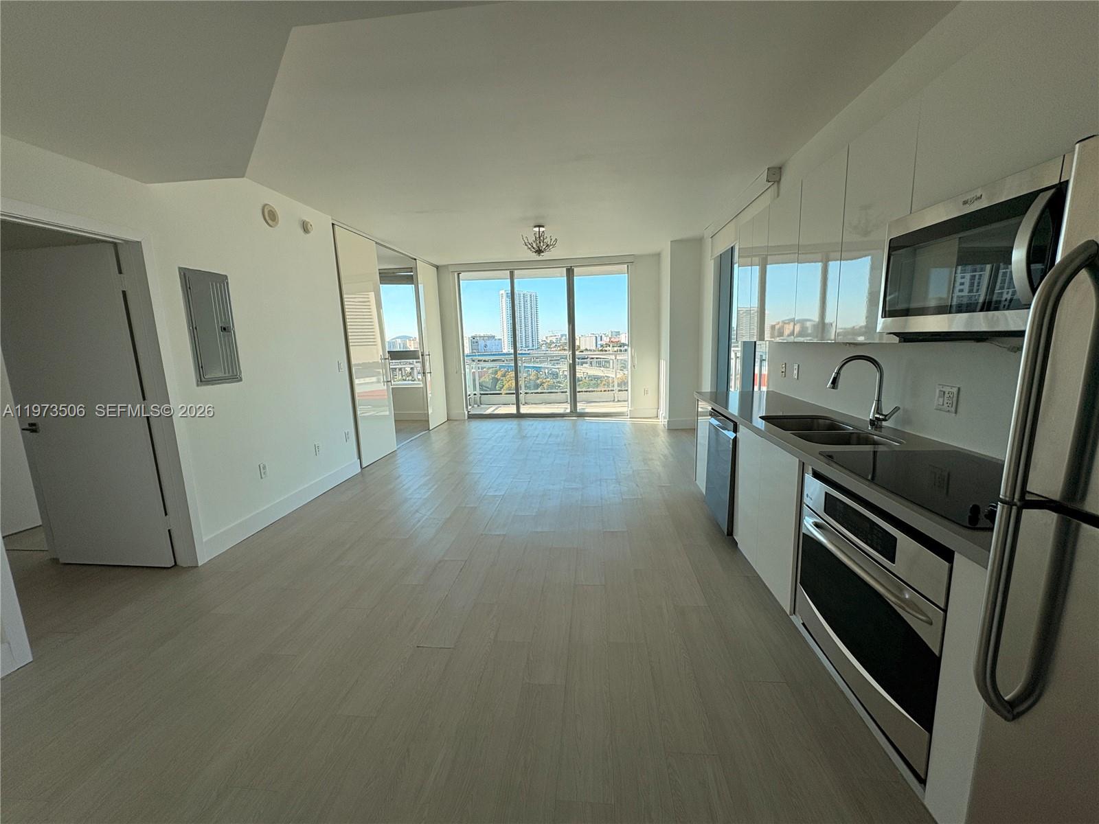 90 Southwest 3rd Street, Unit 1205 Miami, FL 33130 - Photo 8 of 41 a kitchen with granite countertop a sink a refrigerator a stove a microwave and cabinets
