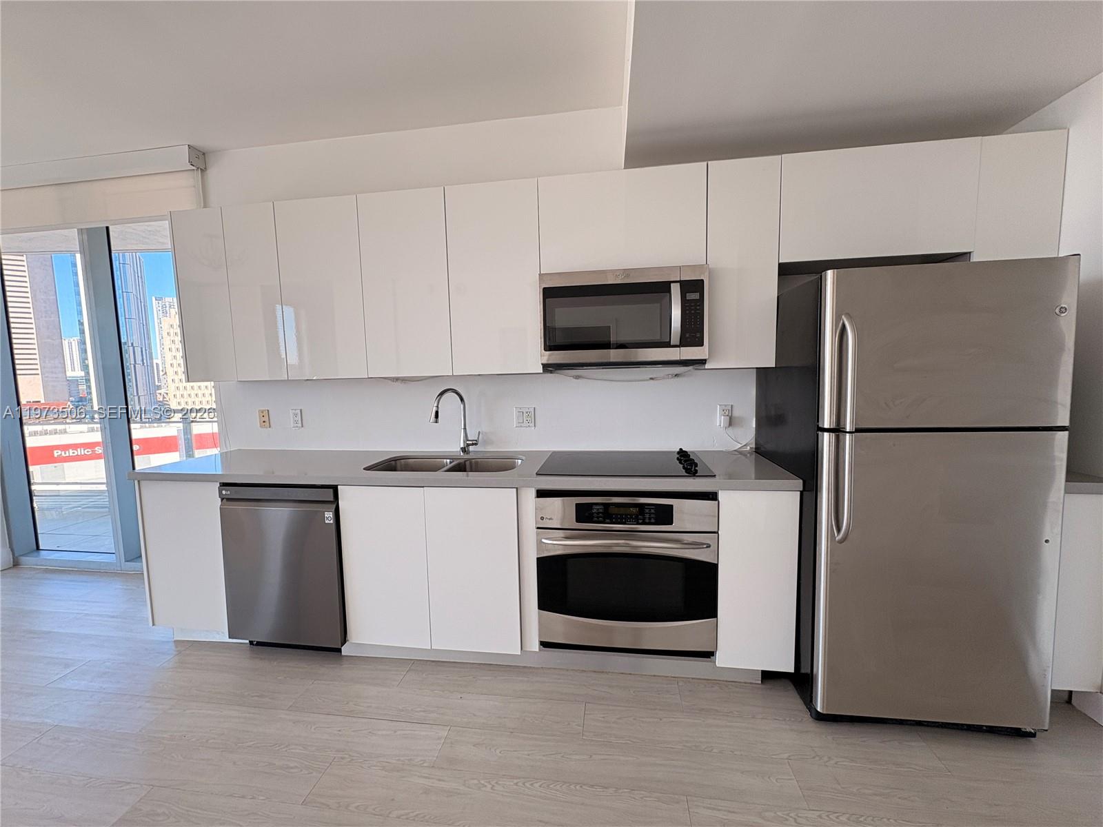 90 Southwest 3rd Street, Unit 1205 Miami, FL 33130 - Photo 10 of 41 a kitchen with a refrigerator stove and white cabinets