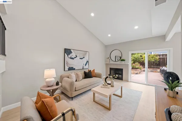 a living room with furniture a fireplace and potted plants with the potted plant