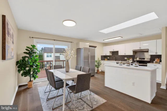 a dining room with furniture and potted plants