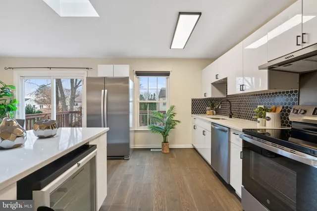 a kitchen with granite countertop a sink stove and refrigerator